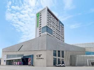 a building with a car parked in front of it at Holiday Inn Express Zhangye By IHG in Zhangye