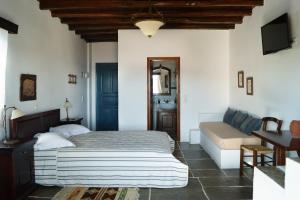 1 dormitorio con 1 cama y 1 sofá en Fassolou, en Faros