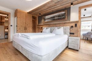 a large white bed in a room with wooden walls at LAUDEGGHOF Ladis in Ladis