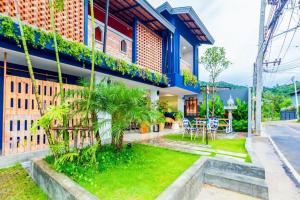 una casa con un giardino davanti di OYO 422 Jane Homestay and Resort a Ban Kata