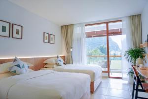 two beds in a hotel room with a window at 悦田生活酒店 in Gaotian +8 photos