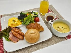 a plate of breakfast food with a sandwich and a bowl of soup at HOTEL SULATA Sapporo (Adult Only) in Sapporo