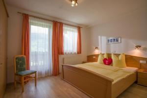 a bedroom with a large bed and a chair at Appartement Hollaus in Fügenberg