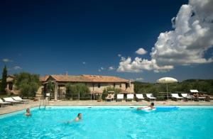 eine Gruppe von Personen, die in einem Schwimmbad schwimmen in der Unterkunft Tenuta Decimo - Il Borgo Di Mariano in San Gimignano