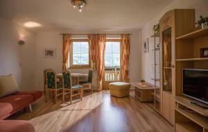 a living room with a table and chairs and a television at Appartements Rosmarie Hollaus in Fügenberg