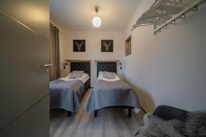 a room with two beds and a couch at Lomavuokra Alpine Chalets Tunturinlaita B9 in Levi