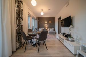 a living room with a table and chairs and a couch at Lomavuokra Alpine Chalets Tunturinlaita B9 in Levi