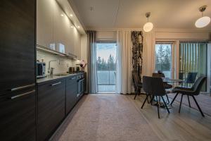 a kitchen with a table and a dining room at Lomavuokra Alpine Chalets Tunturinlaita B9 in Levi