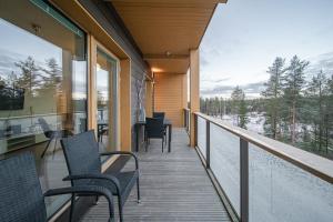 a balcony with chairs and tables on a house at Lomavuokra Alpine Chalets Tunturinlaita B9 in Levi