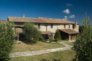 a large stone house with a pathway in front of it at Tenuta Decimo - Il Borgo Di Mariano in San Gimignano