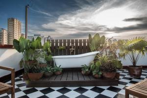 una vasca da bagno seduta su una terrazza con piante di MiraNamin Nest KAMANTIGI - Two Bed Suite in Historic Home with Luxury Indoor Plunge Pool, Garden Access, Self-Service Breakfast, Guest Kitchen, Pet-Friendly a Manila