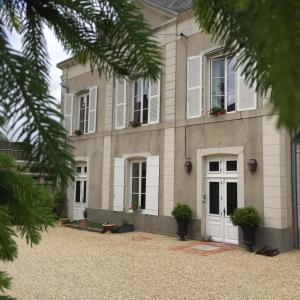 una casa con una puerta y ventanas blancas en Villa des Glycines, en Thouars