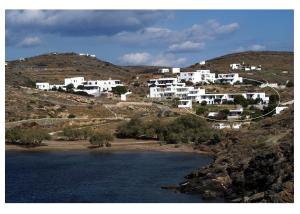 a group of white houses on a hill next to a lake at Fassolou in Faros +22 photos