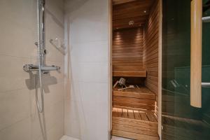 a bathroom with a shower with a wooden wall at Lomavuokra Alpine Chalets Tunturinlaita in Levi +17 photos