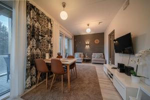 a dining room with a table and a tv at Lomavuokra Alpine Chalets Tunturinlaita in Levi