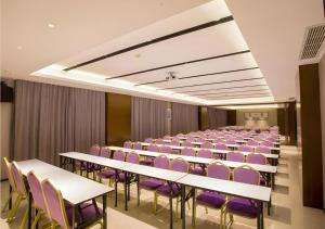 einen Konferenzraum mit weißen Tischen und lila Stühlen in der Unterkunft Borrman Hotel Nanning Railway Station in Nanning