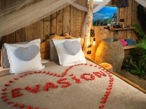 a bed with a heart made out of red flowers at Les biquettes Amoureuses in Carspach +91 photos