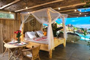 a bedroom with a canopy bed and a table at Les biquettes Amoureuses in Carspach