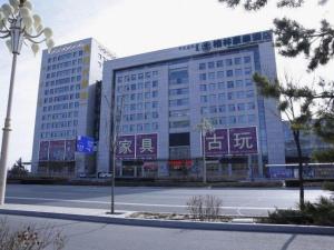 鄂尔多斯GreenTree Inn Ordos Kangbashi District Ulan Mulun Street Branch的一座前面有街道的大楼