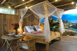 a bedroom with a canopy bed and a table at Les biquettes Amoureuses in Carspach