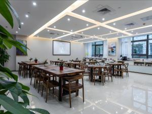 jadalnia z drewnianymi stołami i krzesłami w obiekcie GYA Changzhou Wujin District Hutang New Era Furniture Plaza Hotel w mieście Changzhou