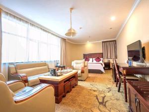 a hotel room with a bed and a living room at Sun Island Holiday Hotel in Shenzhen