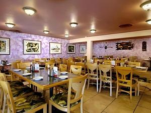 a restaurant with tables and chairs and purple walls at Shalimar Hostel in Las Vegas