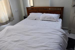 a white bed with white sheets and pillows at Elegant Beach View Flat , Bheemili in Bhīmunipatnam