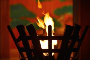 a fire burns in front of a wooden chair at Yamatoya Honten in Matsuyama