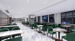 un ristorante con sedie, tavoli e finestre verdi di Nanning Prince Hotel a Nanning