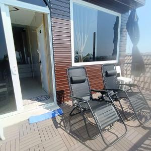 two chairs sitting on the front porch of a house at 49homestay in Ấp Khánh Phước (1)