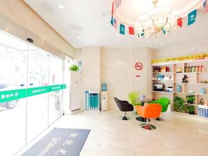 una stanza con tavolo, sedie e lampadario a braccio di GreenTree Inn Shanghai Guangxin Road Tongji Hospital Express Hotel a Shanghai