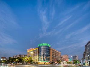 a building with a green sign on top of it at GreenTree Inn HuZhou AnJi YingBin Avenue Express Hotel in Huangshu
