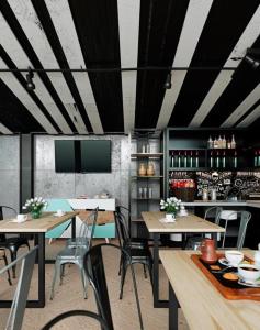 泗水Zoom Dharmahusada Hotel的有桌椅和酒吧的餐厅