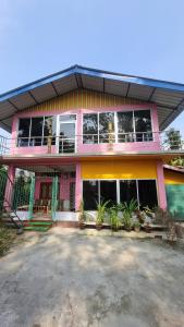 a pink building with a lot of windows at Mayabini The Village Homestay in Bindukuri