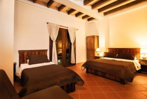 a bedroom with two beds and a couch at Hotel boutique CM in La Vega