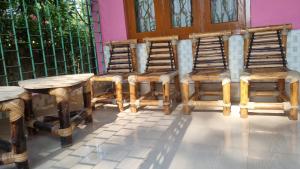 a group of wooden chairs and a table at Mayabini The Village Homestay in Bindukuri +3 photos