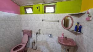 a bathroom with a pink toilet and a sink at Mayabini The Village Homestay in Bindukuri