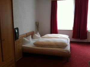 a hotel room with two beds and a television at Hotel Zum Goldenen Löwen in Merseburg
