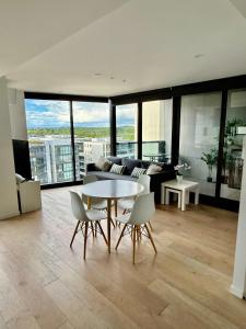 una sala de estar con una mesa, sillas y un sofá en 1BR-1BR-1Car-Sleeps 4-Pool-CBD, en Canberra