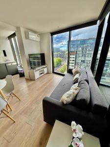 Una sala de estar con un sofá y una ventana grande. en 1BR-1BR-1Car-Sleeps 4-Pool-CBD, en Canberra