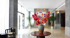 un vaso con fiori su un tavolo in un corridoio di Jinjiang Inn Kunming Changshui Airport a Kunming