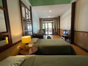 a hotel room with two beds and a lamp at อัมพวาริเวอร์วิว Amphawa River View in Samut Songkhram