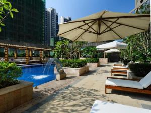 莆田Putian Depo Hotel的一个带遮阳伞和喷泉的游泳池