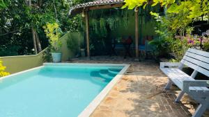 a swimming pool in a yard with a bench at Bouganvilla House in Unawatuna