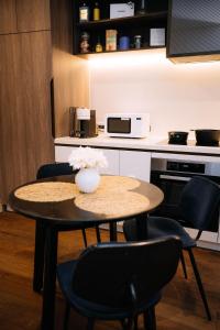 a table with chairs and a vase of flowers on it at 2bedroom city central appletv Homepod pool sauna in Melbourne