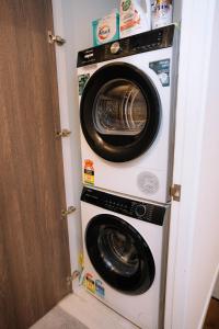 a washing machine and a washer and dryer in a room at 2bedroom city central appletv Homepod pool sauna in Melbourne