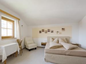 a bedroom with a bed and a chair and a window at Lovely Apartment in Hainzenberg next to Forest in Hainzenberg