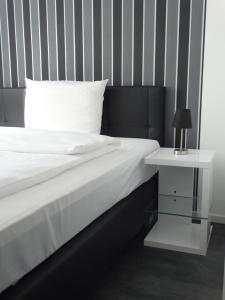 a bed with a white pillow and a side table at Hotel Stay in Essen