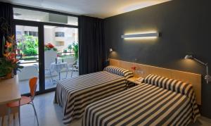 a hotel room with two beds and a balcony at Hotel Nautico in Santa Cruz de Tenerife